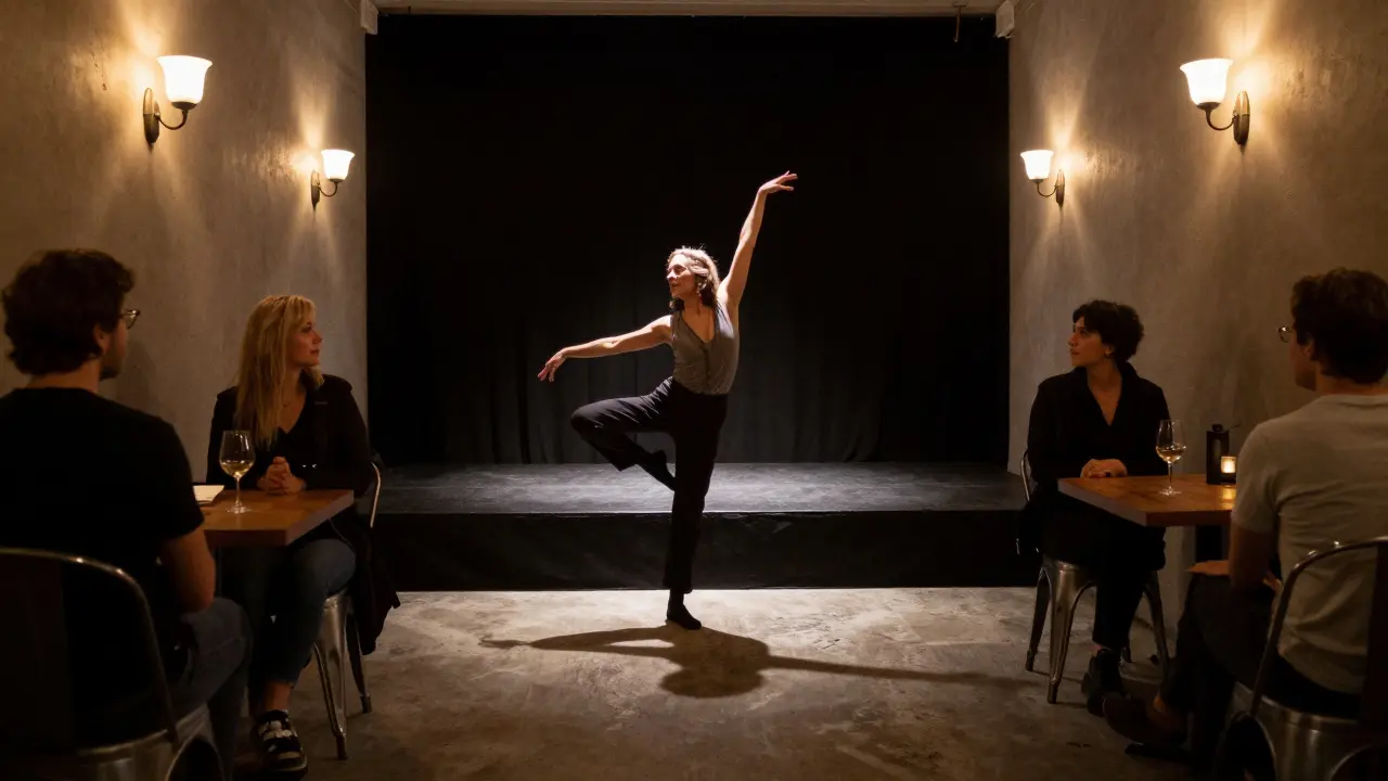 A dancer performing gracefully on a small stage under a spotlight in a modest, intimate venue.